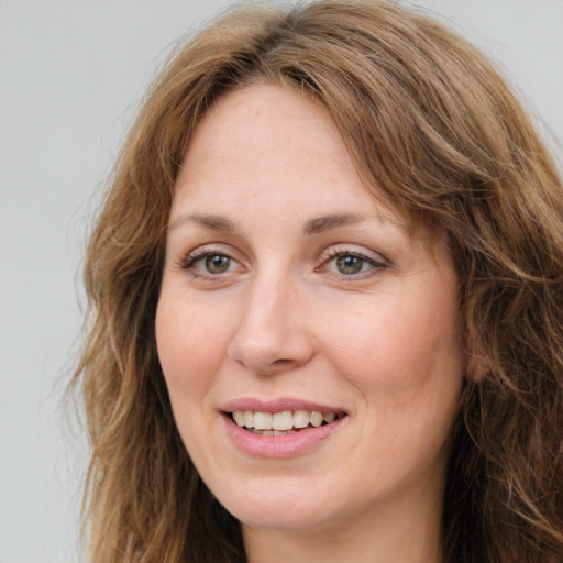 Joyful white young-adult female with long  brown hair and green eyes