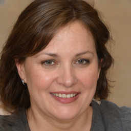 Joyful white adult female with medium  brown hair and brown eyes