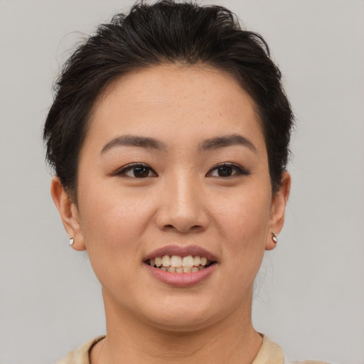 Joyful asian young-adult female with short  brown hair and brown eyes