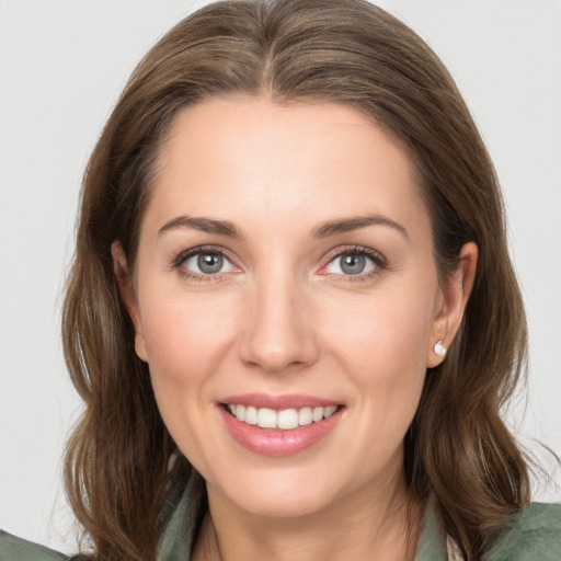 Joyful white young-adult female with medium  brown hair and grey eyes