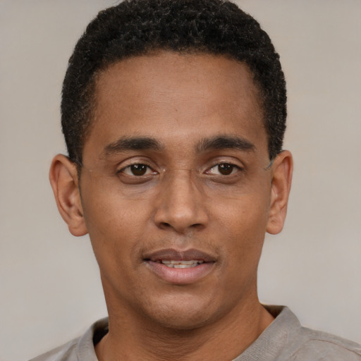 Joyful black young-adult male with short  black hair and brown eyes