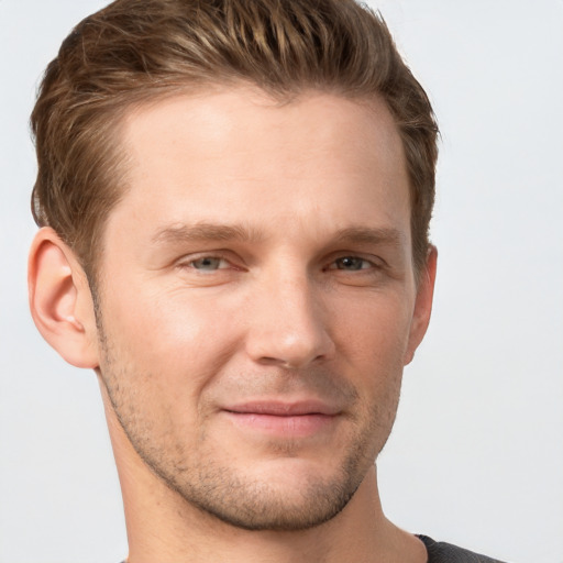 Joyful white young-adult male with short  brown hair and grey eyes