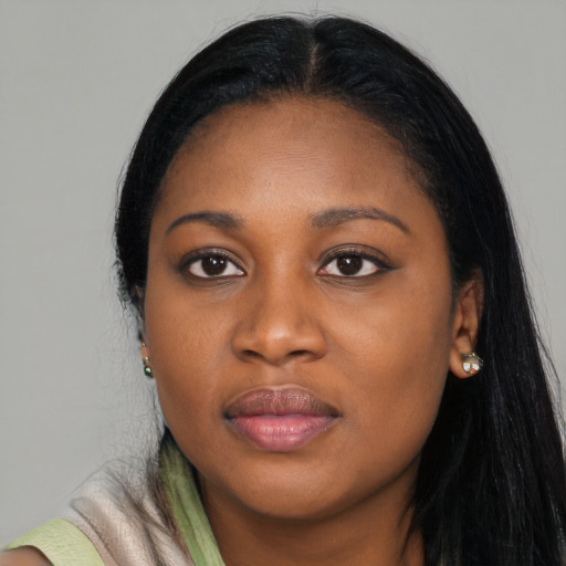 Joyful black young-adult female with long  black hair and brown eyes