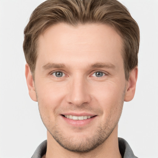 Joyful white young-adult male with short  brown hair and grey eyes