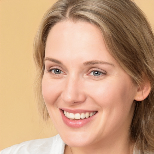 Joyful white adult female with long  brown hair and blue eyes