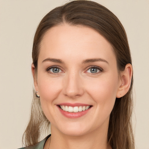 Joyful white young-adult female with long  brown hair and blue eyes