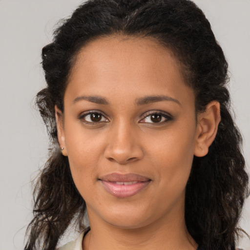 Joyful black young-adult female with long  brown hair and brown eyes