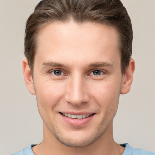 Joyful white young-adult male with short  brown hair and grey eyes