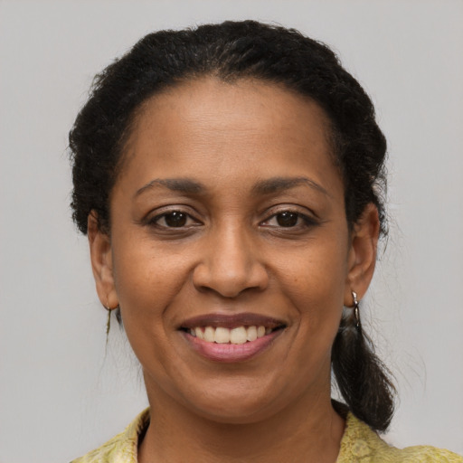 Joyful black adult female with medium  brown hair and brown eyes