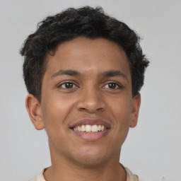 Joyful latino young-adult male with short  brown hair and brown eyes