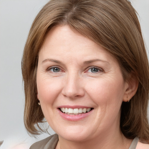 Joyful white adult female with medium  brown hair and grey eyes