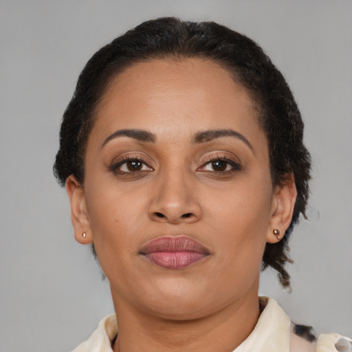 Joyful black adult female with short  brown hair and brown eyes