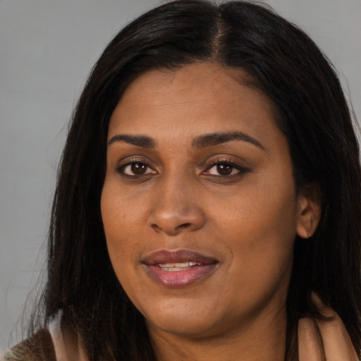 Joyful black young-adult female with long  brown hair and brown eyes