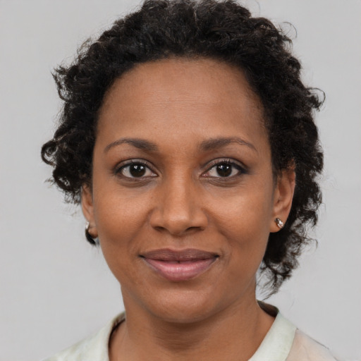 Joyful black adult female with short  brown hair and brown eyes
