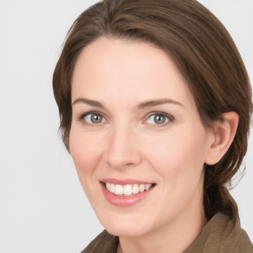 Joyful white young-adult female with medium  brown hair and grey eyes