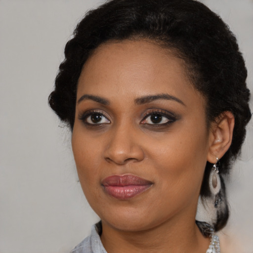 Joyful black young-adult female with medium  brown hair and brown eyes