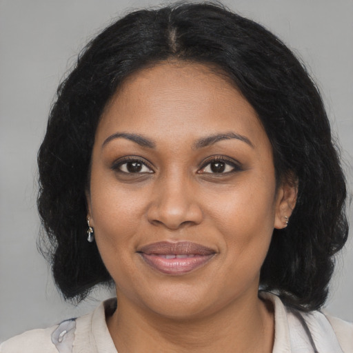 Joyful black adult female with medium  brown hair and brown eyes