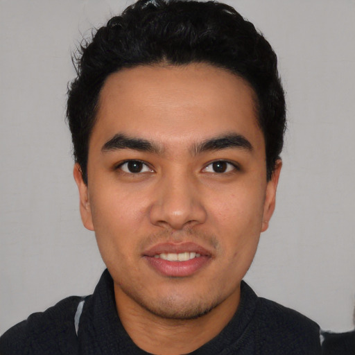 Joyful latino young-adult male with short  black hair and brown eyes