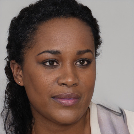 Joyful black young-adult female with long  brown hair and brown eyes