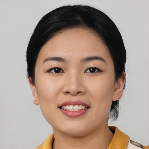 Joyful asian young-adult female with short  black hair and brown eyes