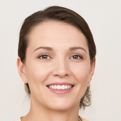 Joyful white young-adult female with medium  brown hair and grey eyes