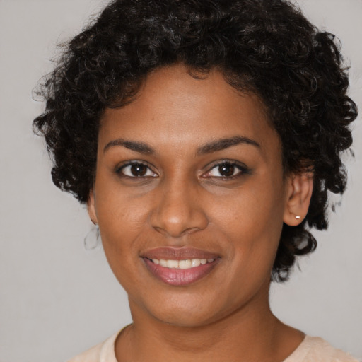 Joyful black young-adult female with short  brown hair and brown eyes