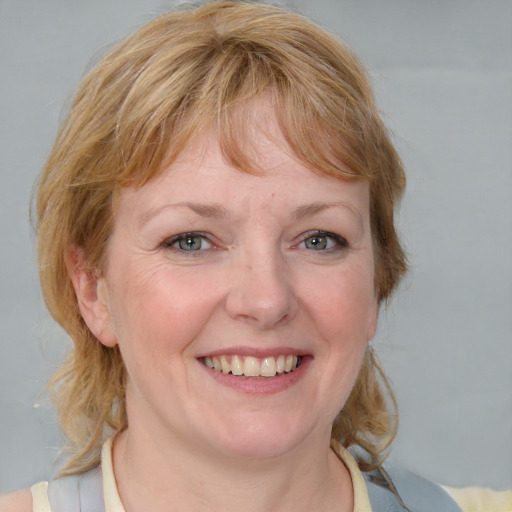 Joyful white young-adult female with medium  brown hair and blue eyes