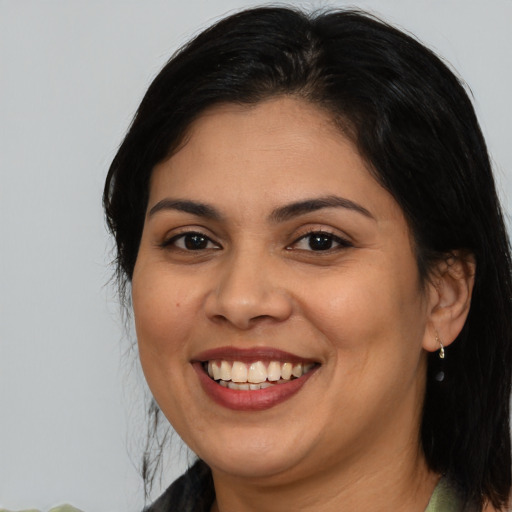 Joyful latino adult female with medium  brown hair and brown eyes