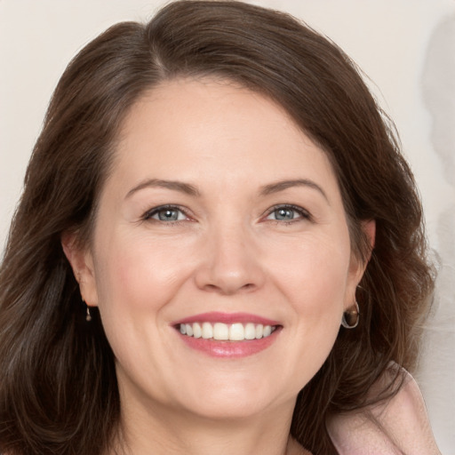 Joyful white adult female with medium  brown hair and grey eyes