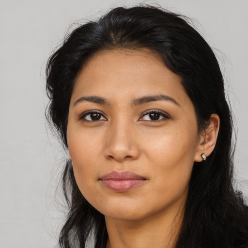 Joyful latino young-adult female with long  brown hair and brown eyes