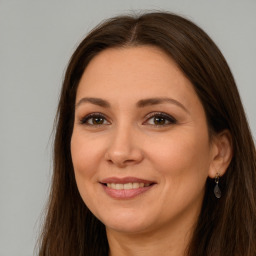 Joyful white adult female with long  brown hair and brown eyes