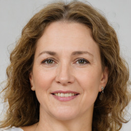 Joyful white adult female with medium  brown hair and green eyes