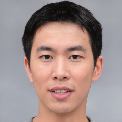 Joyful asian young-adult male with short  black hair and brown eyes