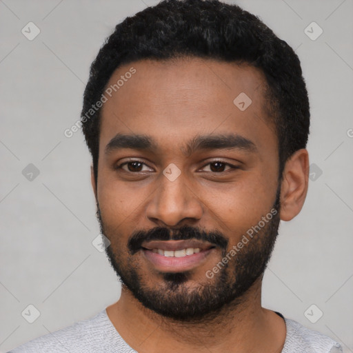 Joyful black young-adult male with short  black hair and brown eyes