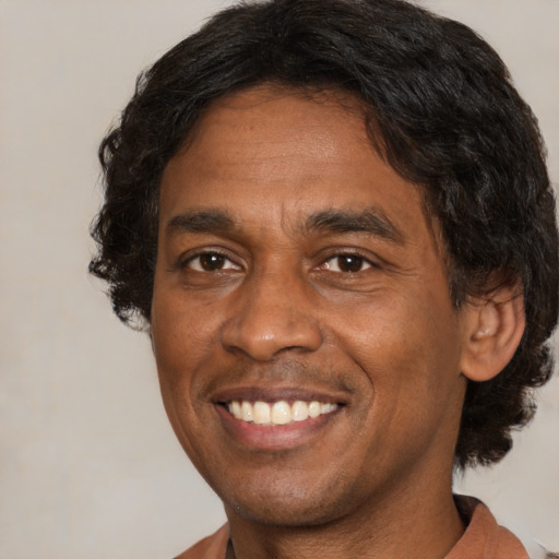 Joyful black adult male with short  brown hair and brown eyes