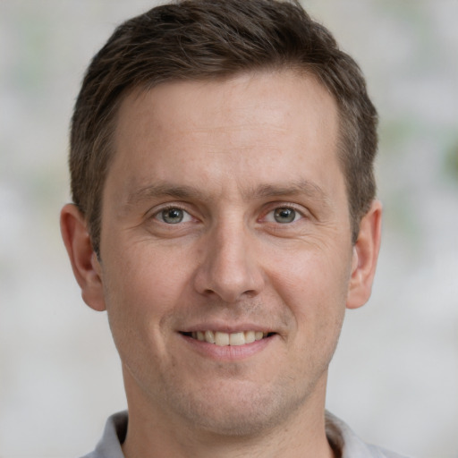 Joyful white adult male with short  brown hair and brown eyes