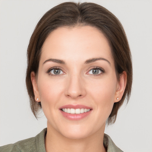 Joyful white young-adult female with medium  brown hair and grey eyes