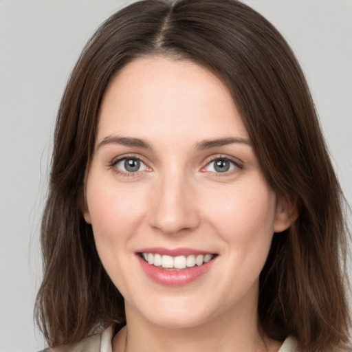 Joyful white young-adult female with medium  brown hair and grey eyes