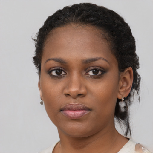 Joyful black young-adult female with short  black hair and brown eyes