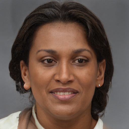 Joyful black adult female with medium  brown hair and brown eyes