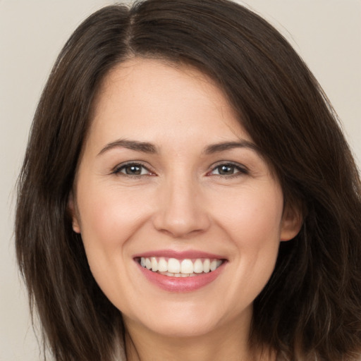 Joyful white young-adult female with long  brown hair and brown eyes