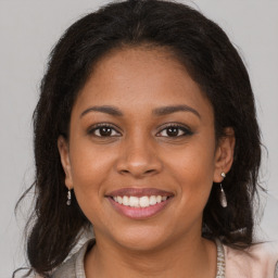 Joyful black young-adult female with long  brown hair and brown eyes