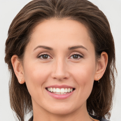 Joyful white young-adult female with long  brown hair and brown eyes