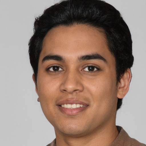 Joyful latino young-adult male with short  black hair and brown eyes