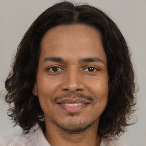 Joyful black young-adult male with medium  brown hair and brown eyes