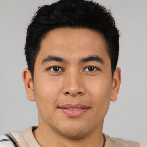 Joyful latino young-adult male with short  brown hair and brown eyes