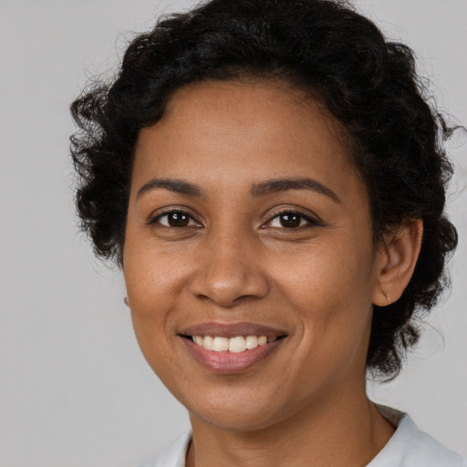 Joyful black young-adult female with medium  brown hair and brown eyes
