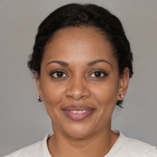 Joyful black young-adult female with short  black hair and brown eyes