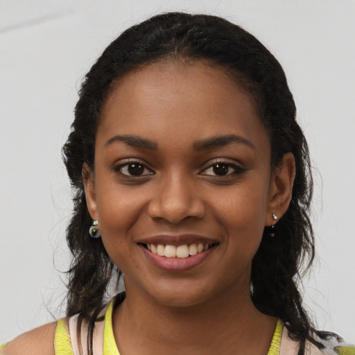 Joyful black young-adult female with long  black hair and brown eyes