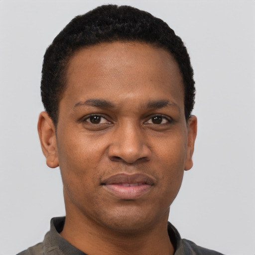 Joyful black young-adult male with short  black hair and brown eyes